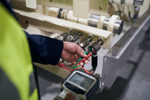 Image depicts a Woodward Group professional conducting fixed wire testing.